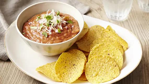 imae of old el paso refried beans in a bowel with tortilla chips beside them